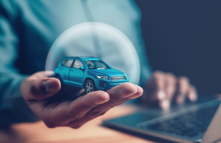 man holding a car while using a laptop